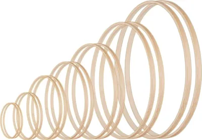A set of wooden rings of varying sizes arranged in a diagonal line, increasing in size from left to right, against a white background.