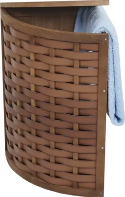 A corner laundry basket made of woven wood with a blue towel inside.