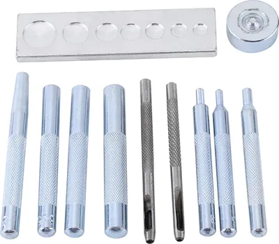 A set of metal tools for setting rivets or snaps, laid out on a white background.