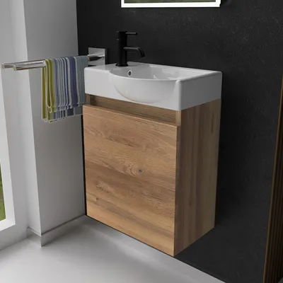 A bathroom vanity with a sink and faucet, with towels hanging on a rack.
