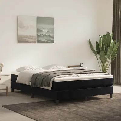 A bedroom scene with a bed, nightstand, and plant.