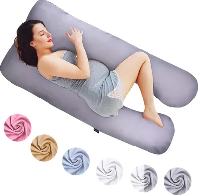 A pregnant woman is lying on a U-shaped pillow.