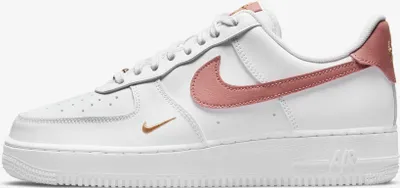 A side view of a white Nike Air Force 1 shoe with pink accents.
