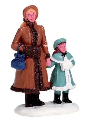 Frau und ein junges Mädchen die sich an den Händen halten und im Schnee stehen.