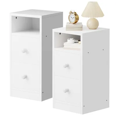 Two white nightstands are shown side-by-side against a white background. The nightstand on the right has a lamp, books, and a clock on top.