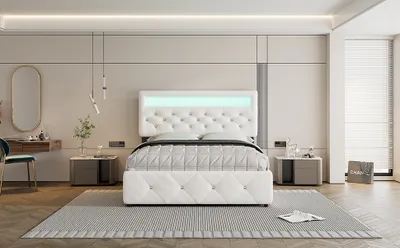 A modern bedroom with a white upholstered bed, two nightstands, a vanity, and a rug.