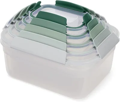 A set of nested food storage containers with green lids.