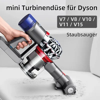 A hand holding a Dyson vacuum cleaner head over a surface.