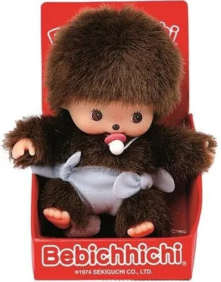 A Monchhichi doll is presented in its packaging.