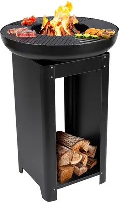 A black outdoor grill with a fire pit and food cooking on top, and firewood stored underneath.