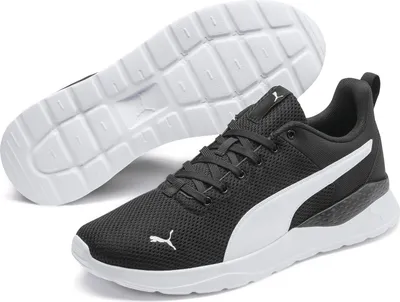 A pair of black Puma sports shoes with white accents, shown from a diagonal angle with the sole of one shoe visible.
