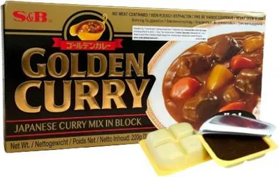 A box of S&B Golden Curry Japanese Curry Mix in Block, with two opened packets of the curry mix shown in the foreground.