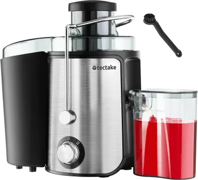 A close-up studio shot of a juicer with red juice in its container and a small cleaning brush next to it.