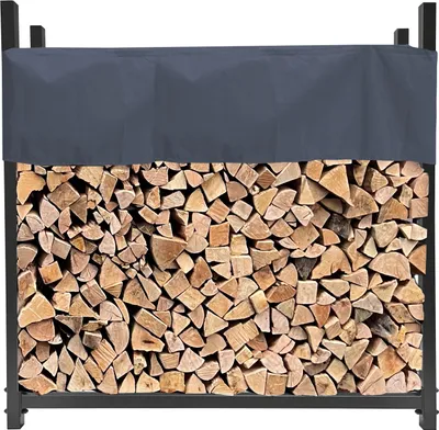 A firewood rack filled with logs, covered by a gray tarp.