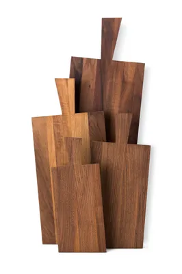 A collection of wooden cutting boards of various sizes and shapes, stacked together.