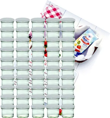 A large set of glass jars with white lids, arranged in rows, with a recipe booklet and a checkered cloth in the background.