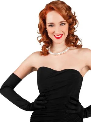 A woman wearing a black strapless dress and long black gloves, with a pearl necklace.