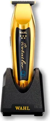 A gold Wahl Detailer cordless hair trimmer is shown standing upright in its black charging base.