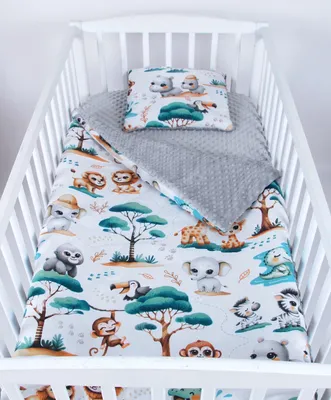 A baby crib with bedding featuring a jungle animal print.