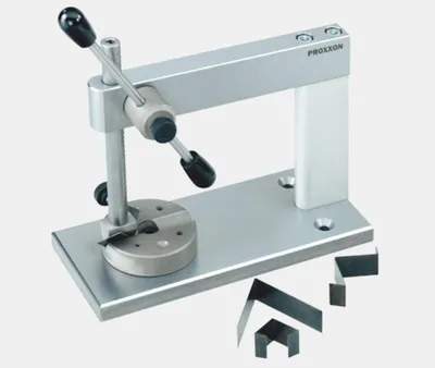 A metal workbench tool with black handles and several small metal pieces on a light gray background.