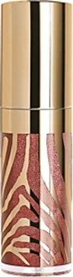A close-up product shot of a makeup product with a gold cap and a glass bottle featuring a zebra-like pattern.