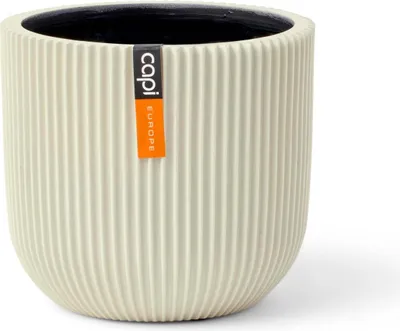 A beige ribbed planter pot with a black interior, featuring a label with the brand name.