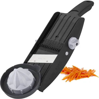 A kitchen mandoline slicer with a julienne attachment and a pile of sliced carrots.