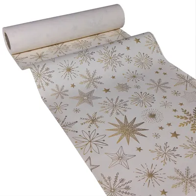 A roll of white paper table runner with gold snowflake and star patterns.