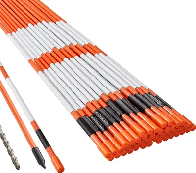A bundle of orange and white driveway markers with black accents, along with a drill bit and a single marker in the foreground.