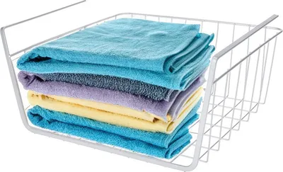 A stack of folded towels in a white wire basket.