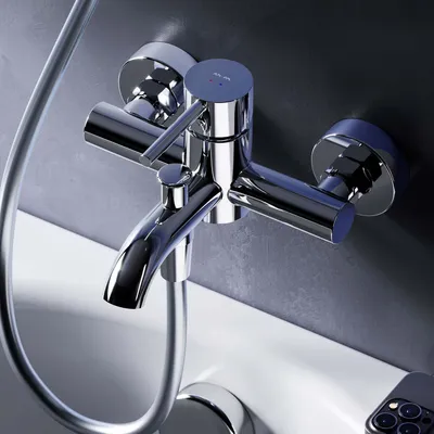 A close-up shot of a chrome bathtub faucet mounted on a wall above a white bathtub.