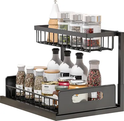 A two-tier sliding cabinet organizer filled with various jars and bottles, likely for spices and condiments.