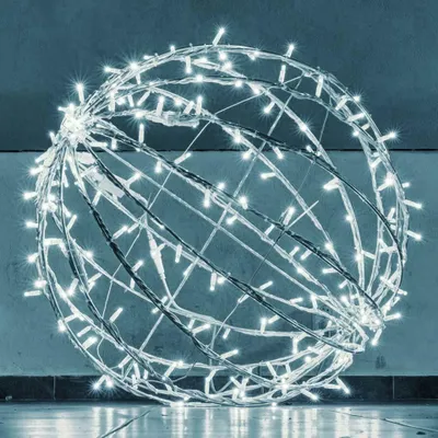 A large, spherical light decoration made of white LED lights on a wire frame, placed indoors on a floor.
