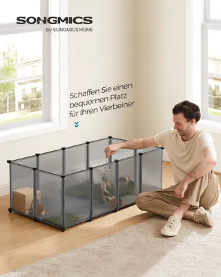A man is interacting with small animals inside a playpen.