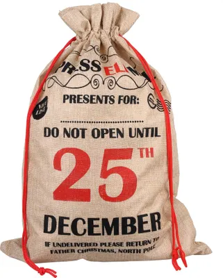 A burlap Christmas sack with red drawstring, printed with holiday-themed text.