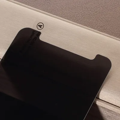 A close-up view of a black screen protector with a small circular sticker labeled 'A' in the top left corner.
