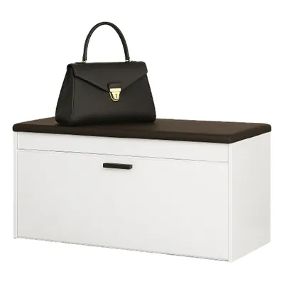A black handbag is placed on top of a white shoe cabinet with a dark brown top.
