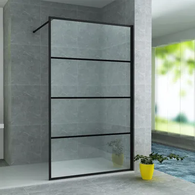 A modern bathroom with a glass shower wall, tiled walls, and a potted plant.