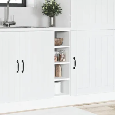 A white kitchen cabinet with a sink and a plant in the background.
