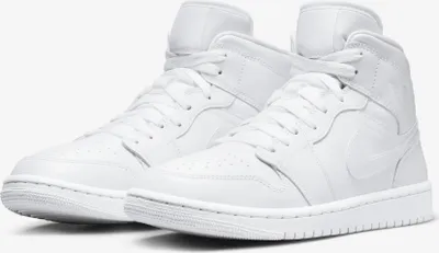 A pair of white Nike Air Jordan 1 Mid sneakers.