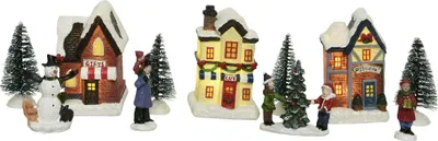 A Christmas village scene with houses, trees, and figures.
