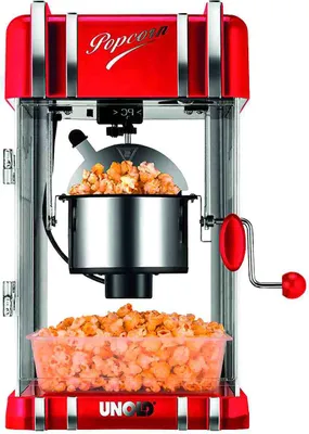 A retro-style red and silver popcorn maker with popcorn inside.