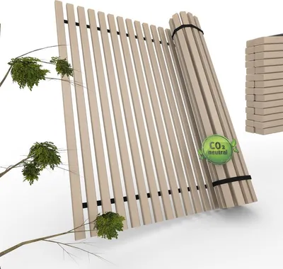 A rolled-up wooden slatted base (Lattenrost) with a CO2 neutral badge, next to some branches and leaves.