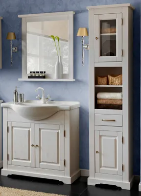 A bathroom vanity and storage cabinet set against a blue textured wall.