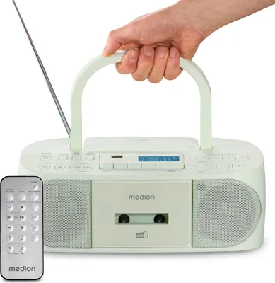A hand holds a portable radio/cassette player with a remote control in the foreground.