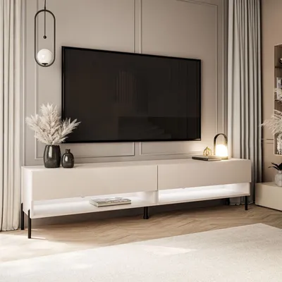 A modern living room with a TV stand, TV, and decorative items.