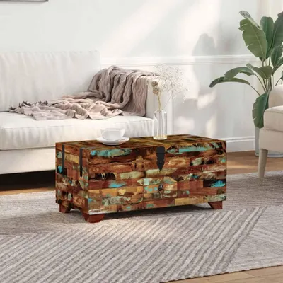 A chest coffee table is placed on a rug in front of a sofa in a living room.