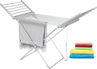 An electric heated clothes drying rack with a towel draped over it and a stack of colorful towels next to it.