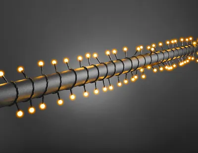 A string of yellow lights wrapped around a dark cylindrical object.