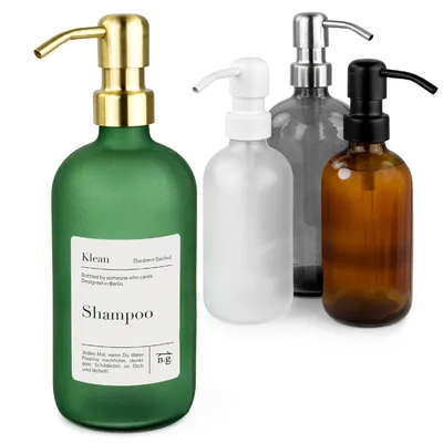 Four soap dispensers of different colors and pump head materials are arranged in a group against a white background.